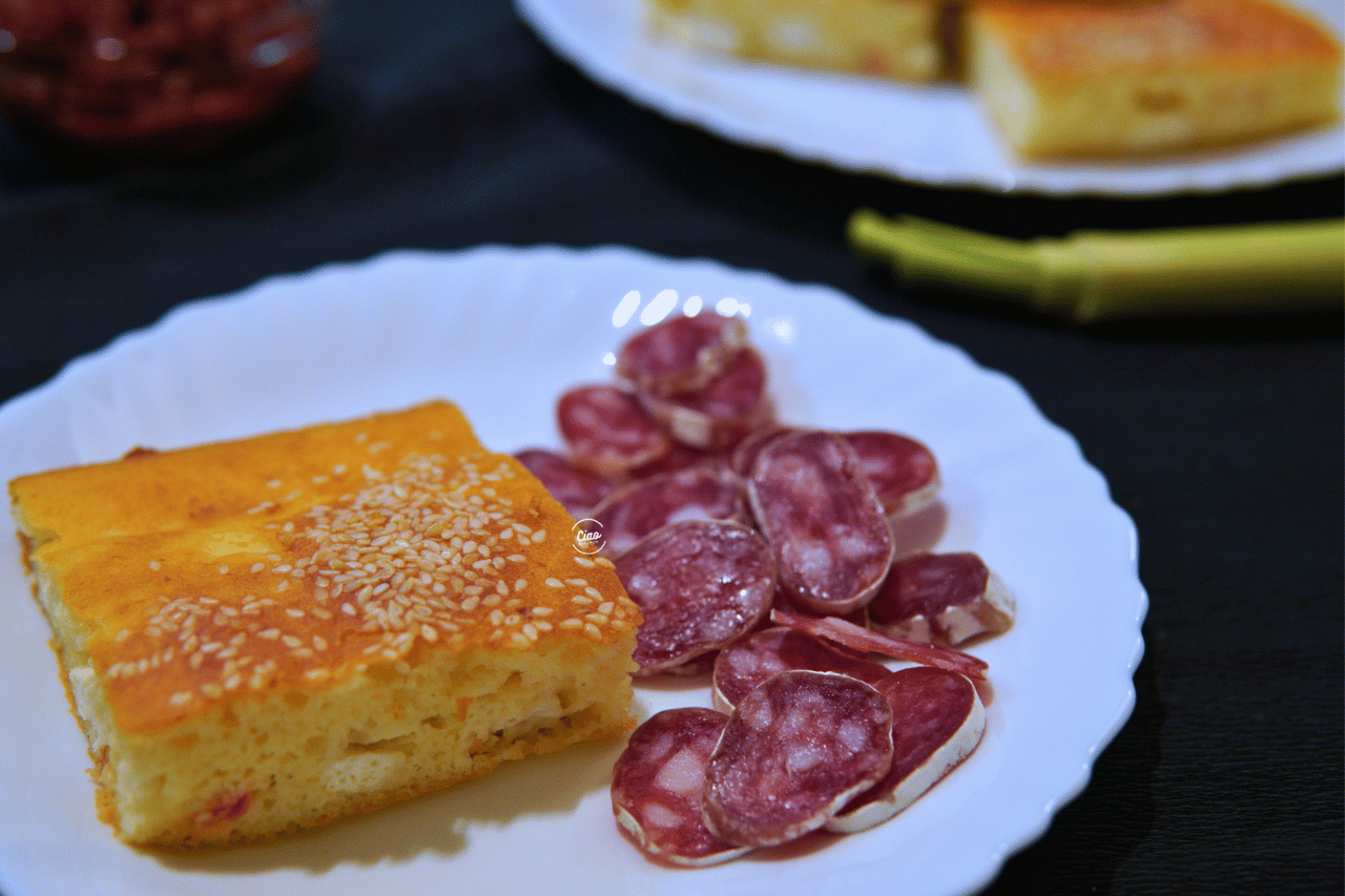 Parče proje na belom tanjiru i kobasica, Piece of cornbread on white plate and sausage